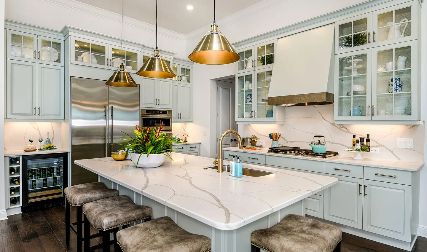 Bright designer kitchen with brass pendant lighting in a Neal Signature home